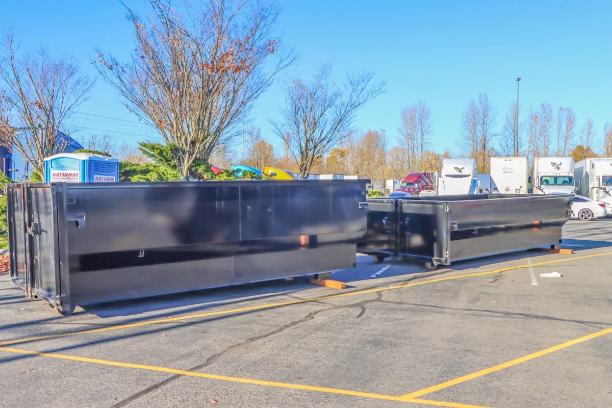 Professional dumpster rental service with roll-off container on residential driveway in Plaistow